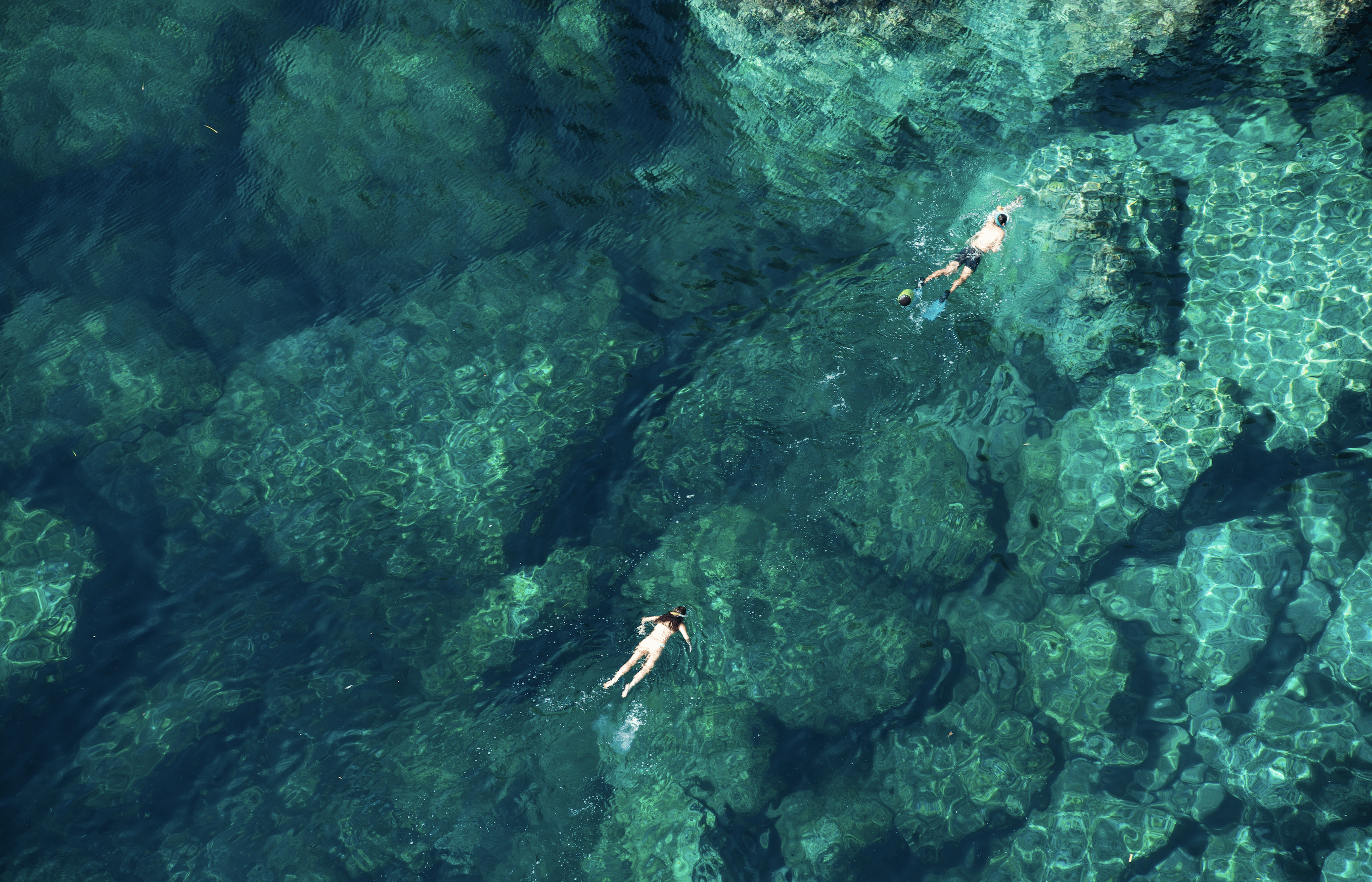 two people swimming photo taken with drone