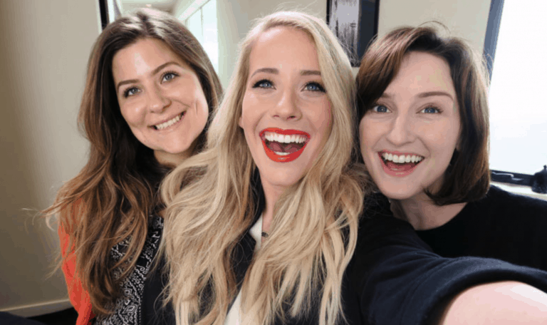 three women posing smiling for a photo