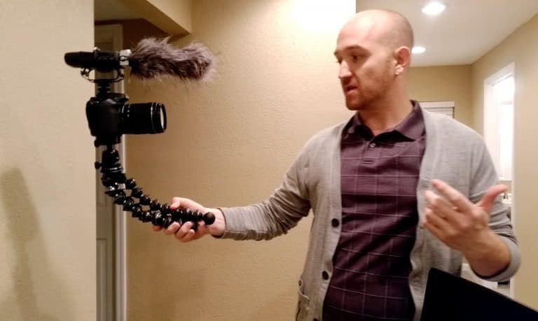 man holding a camera by the tripod