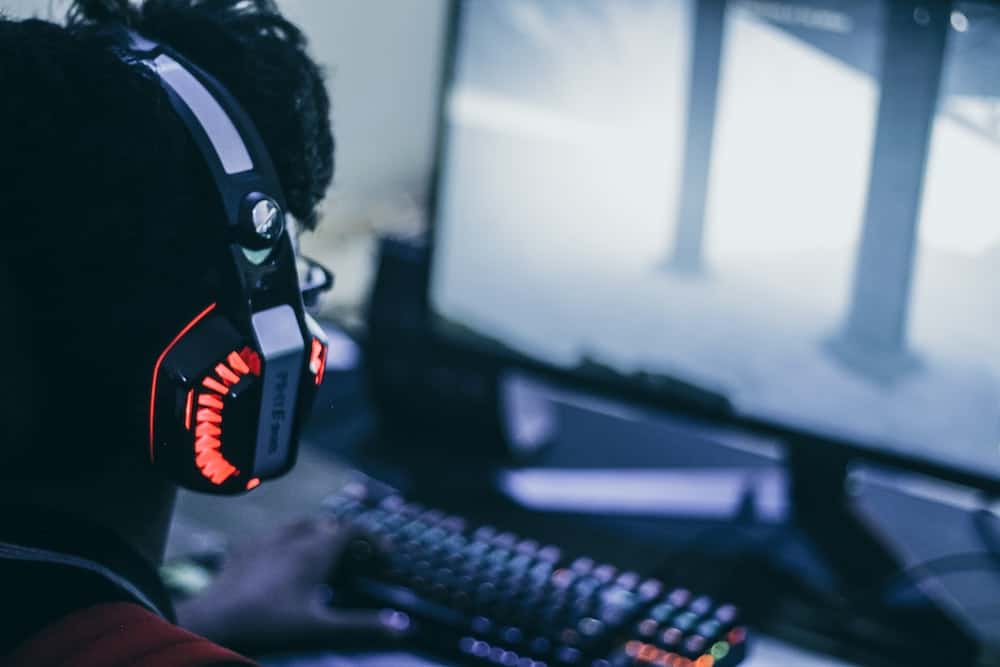 man playing on pc with gamer headphones