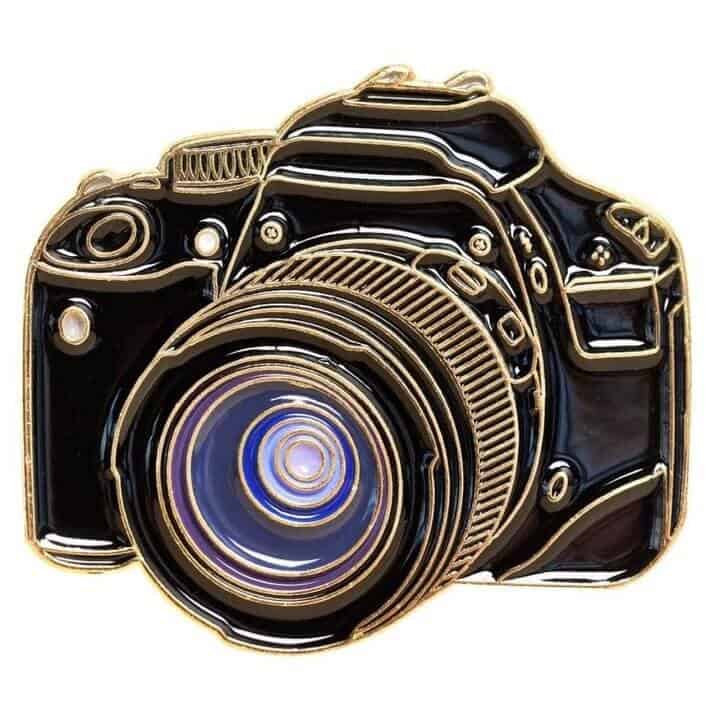 a pin in the shape of a slr camera
